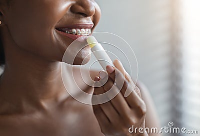 Unrecognizable african american woman applying hygienic lip balm Stock Photo