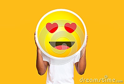 Unrecognizable black man hiding face against in love emoticon emoji Stock Photo