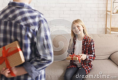 Unrecognizable Boy Holding Gift Congratulting Sister On Birthday At Home Stock Photo