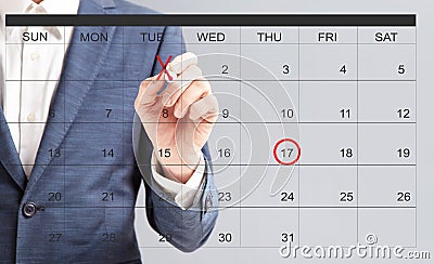 Unrecognizable businessman hand marking dates with red marker on virtual calendar Stock Photo
