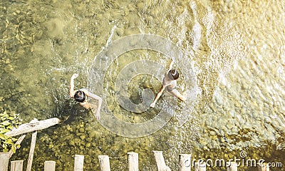 Unrecognizable children swimming in Nam Song river in Vang Vieng - Real everyday healthy life and fun of playful kids in Laos PDR Editorial Stock Photo