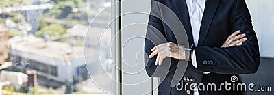 Unrecognizable confident mature businessman with folded arms standing in office near window, panorama, copy space Stock Photo