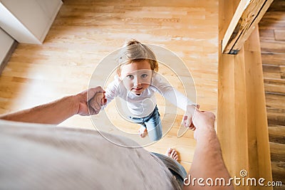 Unrecognizable father with his cute little daughter at home. Stock Photo