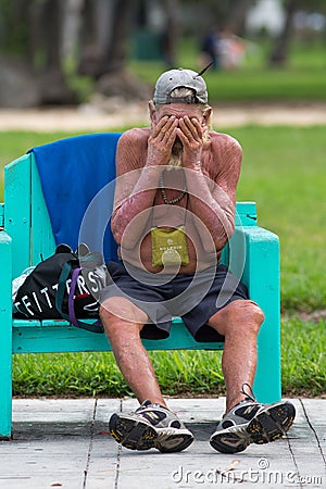 Unrecognizable homeless in Miami Beach sitting on a bench Editorial Stock Photo