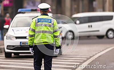 Unrecognizable local police agent. Romanian police man, traffic police man Politia Rutiera directing traffic in Bucharest, Editorial Stock Photo