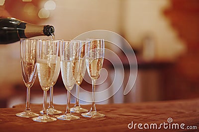 Unrecognizable male filling wineglass with champagne while standing on banquet tabl Stock Photo