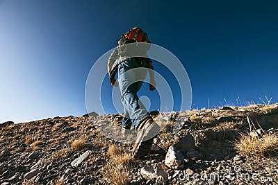 Unrecognizable male traveler goes uphill Stock Photo