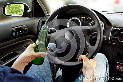 Unrecognizable man drinking and driving. Dangerous driving conce Stock Photo