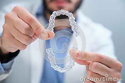 Unrecognizable orthodontist holding trainer dental braces. Stock Photo