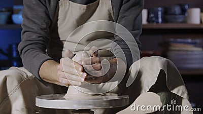 An unrecognizable potter sculpts soft clay with wet hands on a potter& x27;s wheel. Clay shaping and sculpting, close up Stock Photo