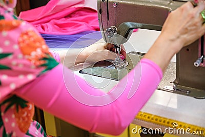 Unrecognizable seamstress threading sewing machine. Stock Photo