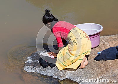 Unrecognizable woman doing the laundry in a river Editorial Stock Photo