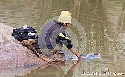 Unrecognizable woman doing the laundry in a river Editorial Stock Photo