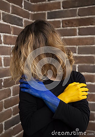 Unrecognizable woman, her face covered by hair, exhaustedly holding her hands in front of her Stock Photo