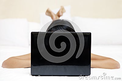 Unrecognizable woman using laptop in bedroom Stock Photo