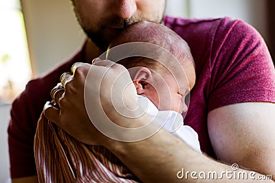 Unrecognizable young father at home holding his newborn baby gir Stock Photo