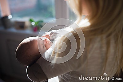 Unrecognizable young mother holding baby son in her arms Stock Photo