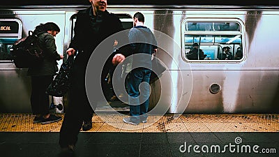 Unrecognized American people leaving and boarding train at underground subway station platform in New York City, USA Editorial Stock Photo