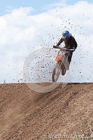 Unrecognized athlete riding a sports motorbike jumping on the air on a motocross race. Fast speed extreme sport Editorial Stock Photo