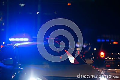 unreconizable road police car with turned on red and blue siren light on its roof on night city road Stock Photo