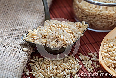 Unrefined rice and metallic old spoon Stock Photo