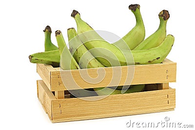 Unripe baking bananas plantain bananas in a wooden crate Stock Photo