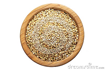 Unroasted buckwheat in a wooden plate. Isolated on a white background Stock Photo