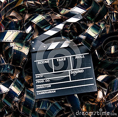 Unrolled heap 35mm movie filmstrip color carpet and clapperboard Stock Photo