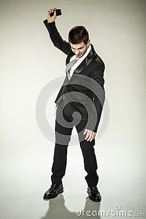 Unsatisfied businessman wants to destroy phone Stock Photo