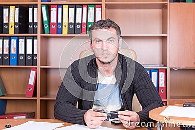 Unshaven man in office with pen Stock Photo