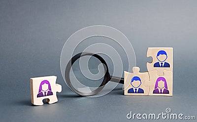 Unsorted team puzzle and magnifying glass. Search, recruitment staff, hiring leader. Lack of specialists in the labor market. Stock Photo