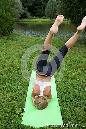 An unsuccessful attempt by a girl to perform a yoga pose. Stock Photo