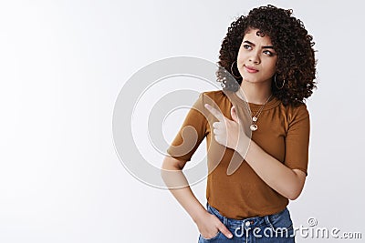 Unsure smart attractive curly-haired girl frowning smirking pointing left look thoughtful pondering important decision Stock Photo