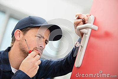 Unsured carpenter install door lock with wireless screwdriver Stock Photo