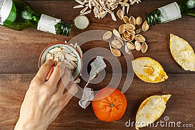 Untidy, messy after party table top view with sunflower seeds, pistachios, leftover shells and orange peels Stock Photo