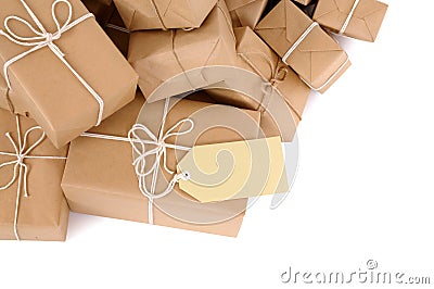 Border pile of brown paper wrapped parcels, one with blank label, isolated on white Stock Photo