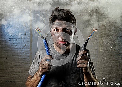 Untrained man joining electrical cable suffering electrical accident with dirty burnt face in funny shock expression Stock Photo