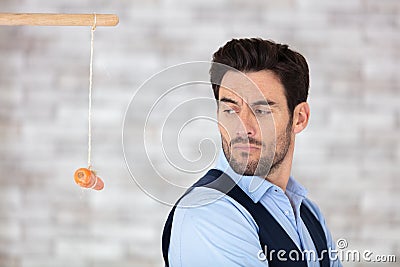 untrusting businessman looking over shoulder at dangling carrot Stock Photo