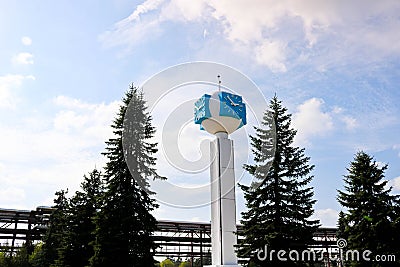 Unusual clock on a background of a white-blue sky. A clock in the form of a molecule, an atom. chemical production, a watch-column Stock Photo