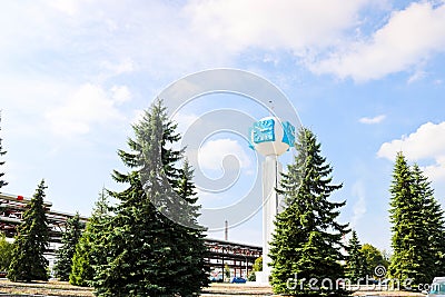 Unusual clock on a background of a white-blue sky. A clock in the form of a molecule, an atom. chemical production, a watch-column Stock Photo