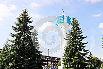 Unusual clock on a background of a white-blue sky. A clock in the form of a molecule, an atom. chemical production, a watch-column Stock Photo
