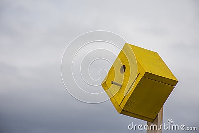 Yellow Birdhouse With Cloudy Sky Background Stock Photo