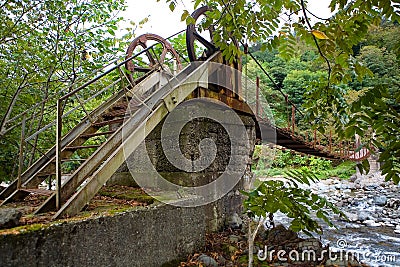 An unusual interesting hinged bridge over a mountain river Stock Photo