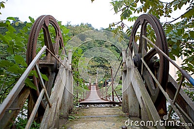 An unusual interesting hinged bridge over a mountain river Stock Photo