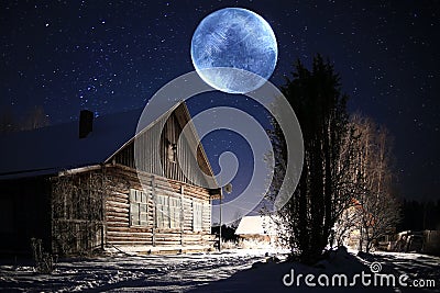 Unusual moons above winter village Stock Photo