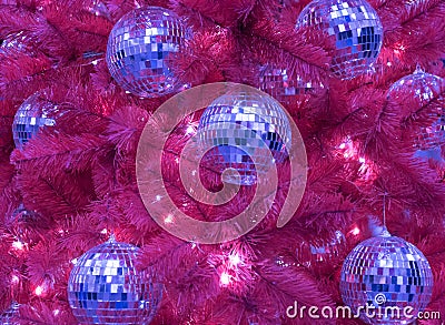 An unusual red Christmas tree. The Christmas tree is decorated with disco balls. Concept of style. Trend. Courage and Stock Photo