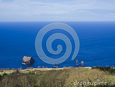 Unusual shaped volcanic rocks formation islets at Mosteiros beach, praia Mosteiros with dried trees coastline and blue Stock Photo