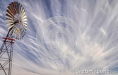 Unusual wind swiped clouds with windmill Stock Photo