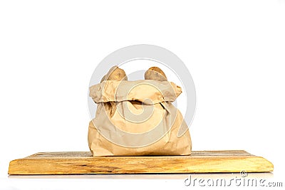 Unwashed potatoes in a paper bag islated on white Stock Photo