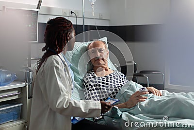 Unwell senior patient laying in bed breathing through oxygen test tube Stock Photo